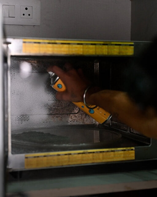 Customer spraying foam inside a greasy kitchen appliance